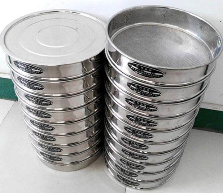 Stacked stainless steel test sieves with lids, showing frame and mesh details for confirming test sieve specifications.